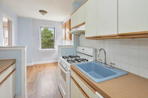 a kitchen with sink stove and window