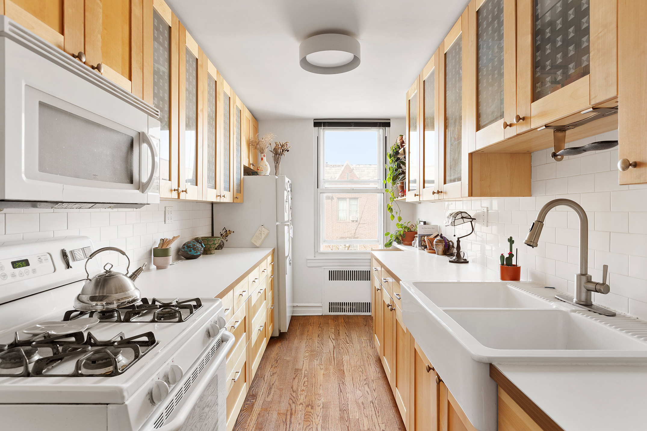 35-05 72nd Street, Unit 4E Queens, NY 11372 - Photo 2 of 10 a kitchen with stainless steel appliances a sink a stove and a wooden floors