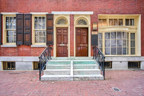 a front view of a house with a lots of windows and plants