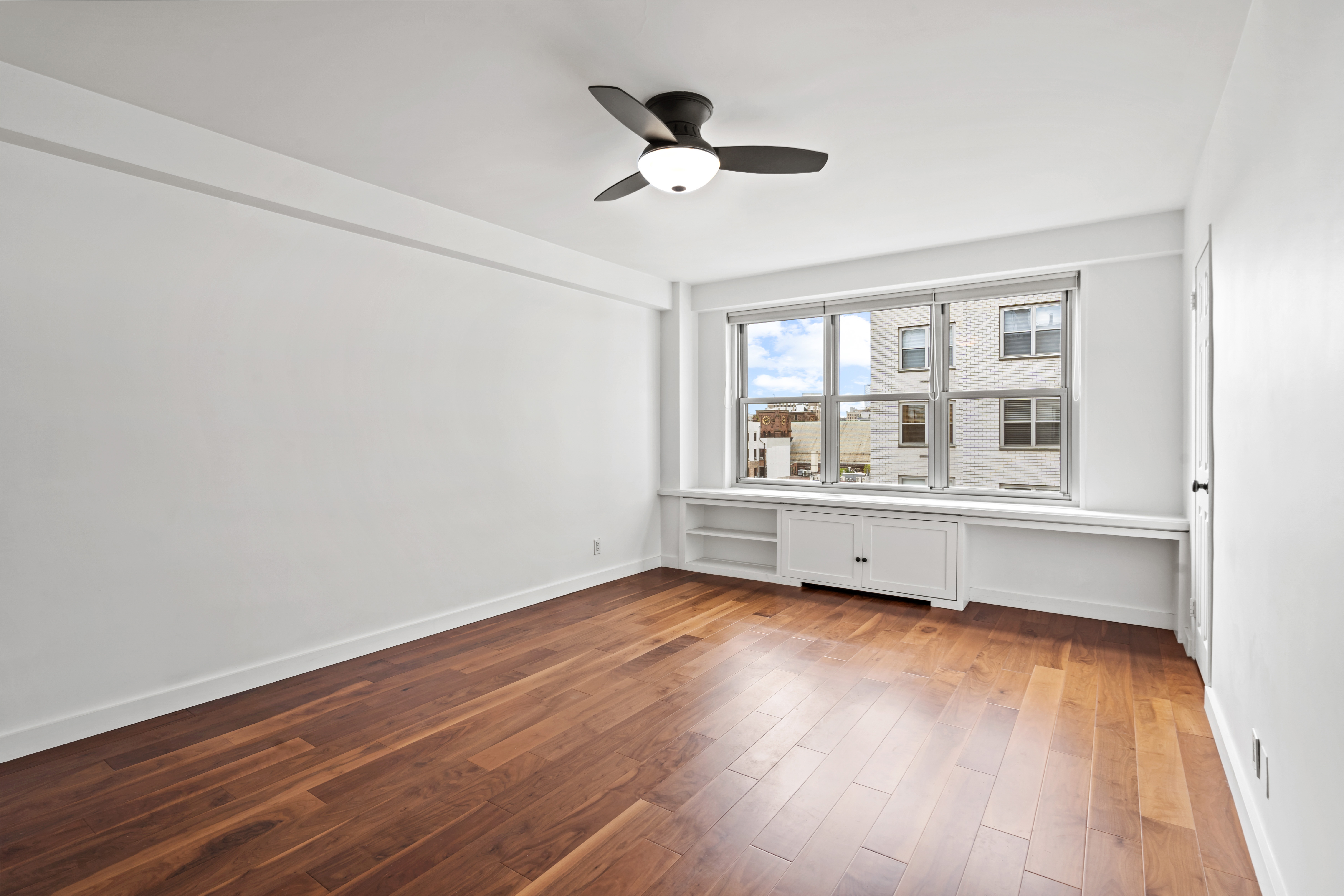 205 3rd Avenue, Unit 11T Manhattan, NY 10003 - Photo 8 of 20 a view of an empty room with wooden floor and a window