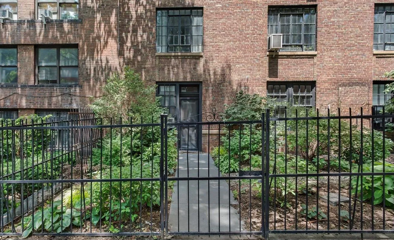 a view of a house with a small yard and wooden fence