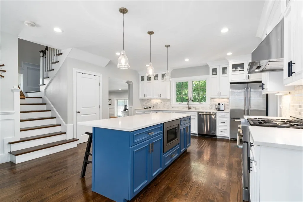 a kitchen with stainless steel appliances kitchen island a stove a sink a refrigerator and a view of living room