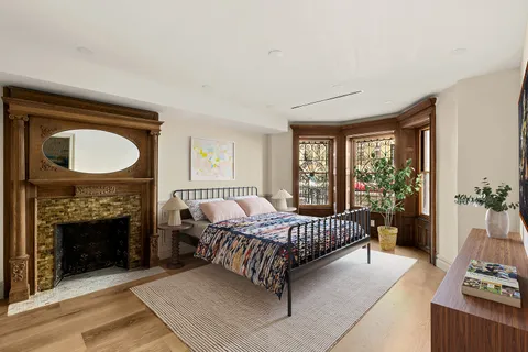 a spacious bedroom with a bed and a fireplace