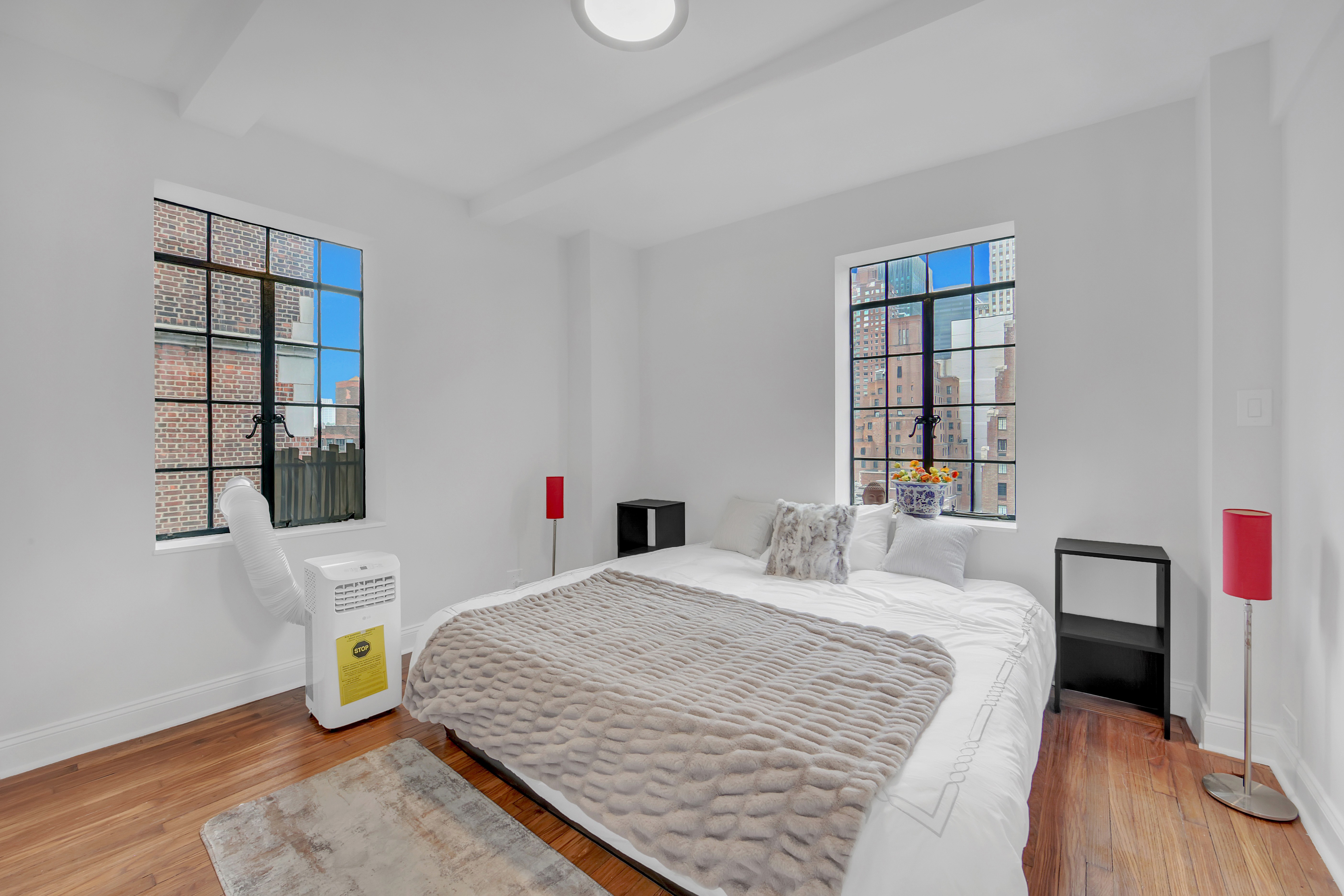 25 Tudor City Place, Unit 1405 Manhattan, NY 10017 - Photo 7 of 21 a bedroom with a bed a couch and a window