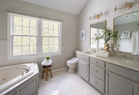 a spacious bathroom with a granite countertop tub a double sink and a window