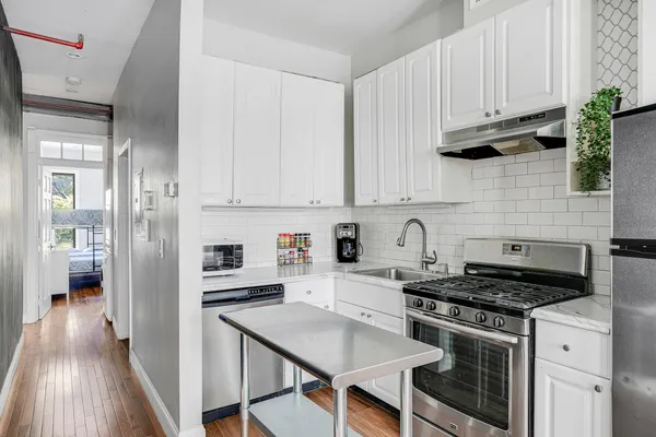 a kitchen with stainless steel appliances granite countertop a stove and a refrigerator