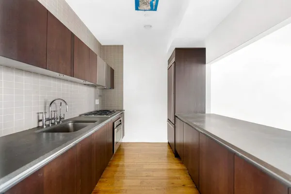 a kitchen with granite countertop a sink and a stove top oven
