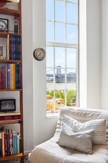 a living room with large window and a book shelf