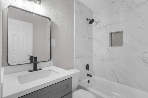 a bathroom with a sink a toilet and shower