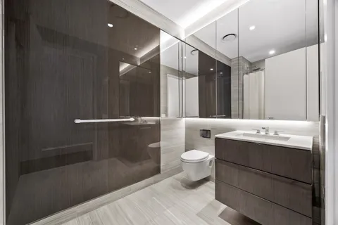 a bathroom with a sink a toilet and shower
