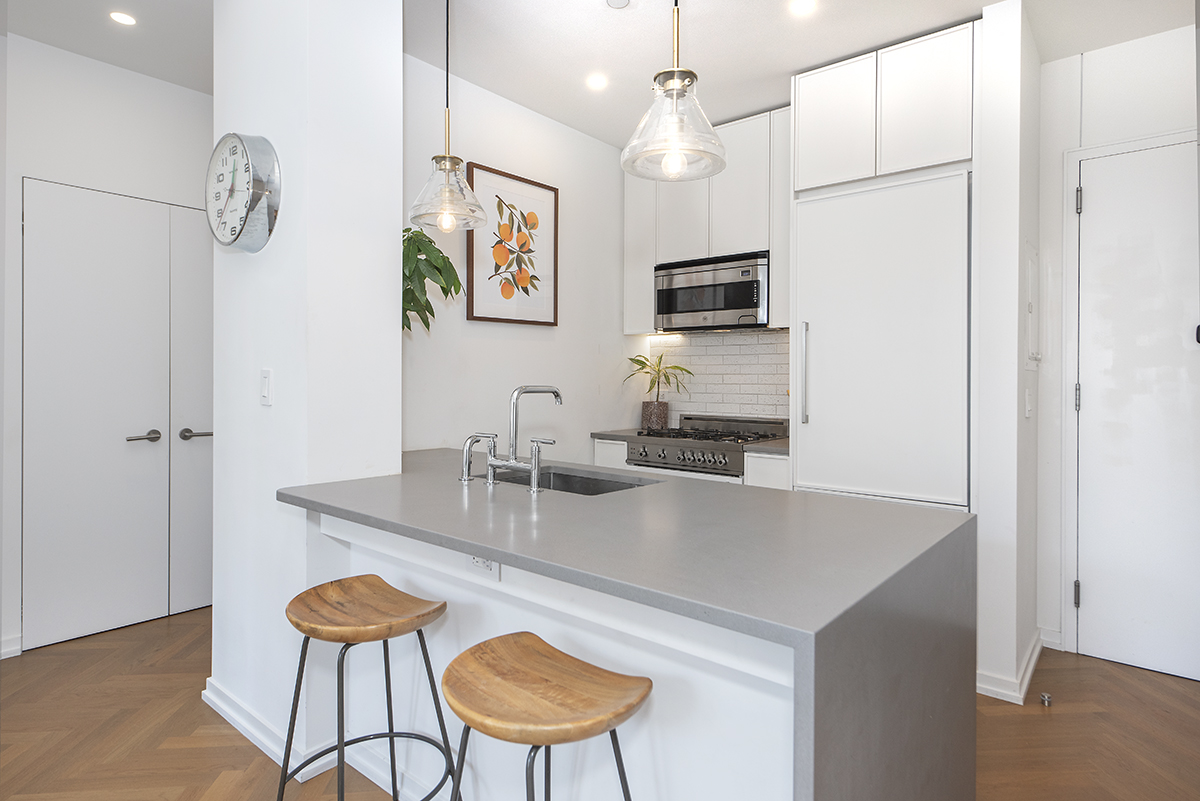 184 Kent Avenue, Unit D519 Brooklyn, NY 11249 - Photo 3 of 17 a kitchen with stainless steel appliances granite countertop a sink a stove a microwave a counter space and refrigerator