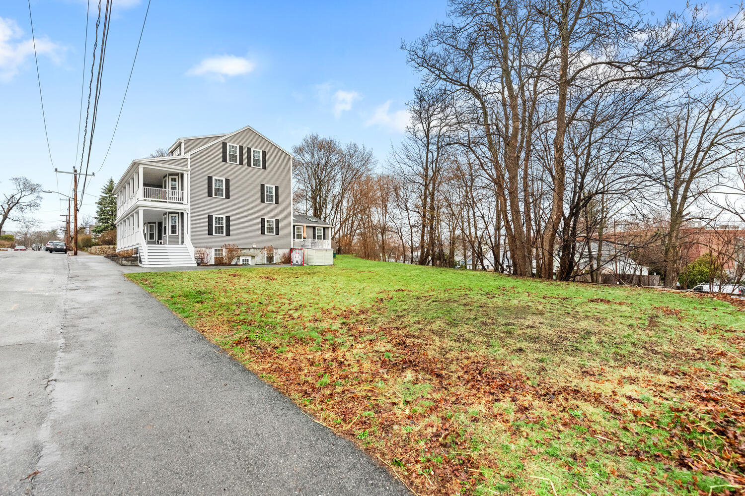 1 Maple Street, Unit 1 Maynard, MA 01754 - Photo 31 of 42 a view of a white house with a big yard and large trees