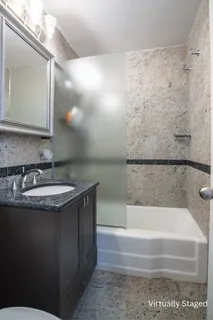 a bathroom with a granite countertop sink a mirror and bathtub