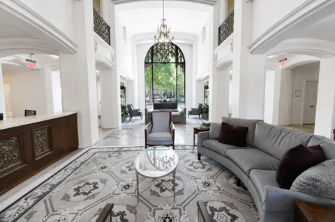 a living room with furniture a fireplace and large windows