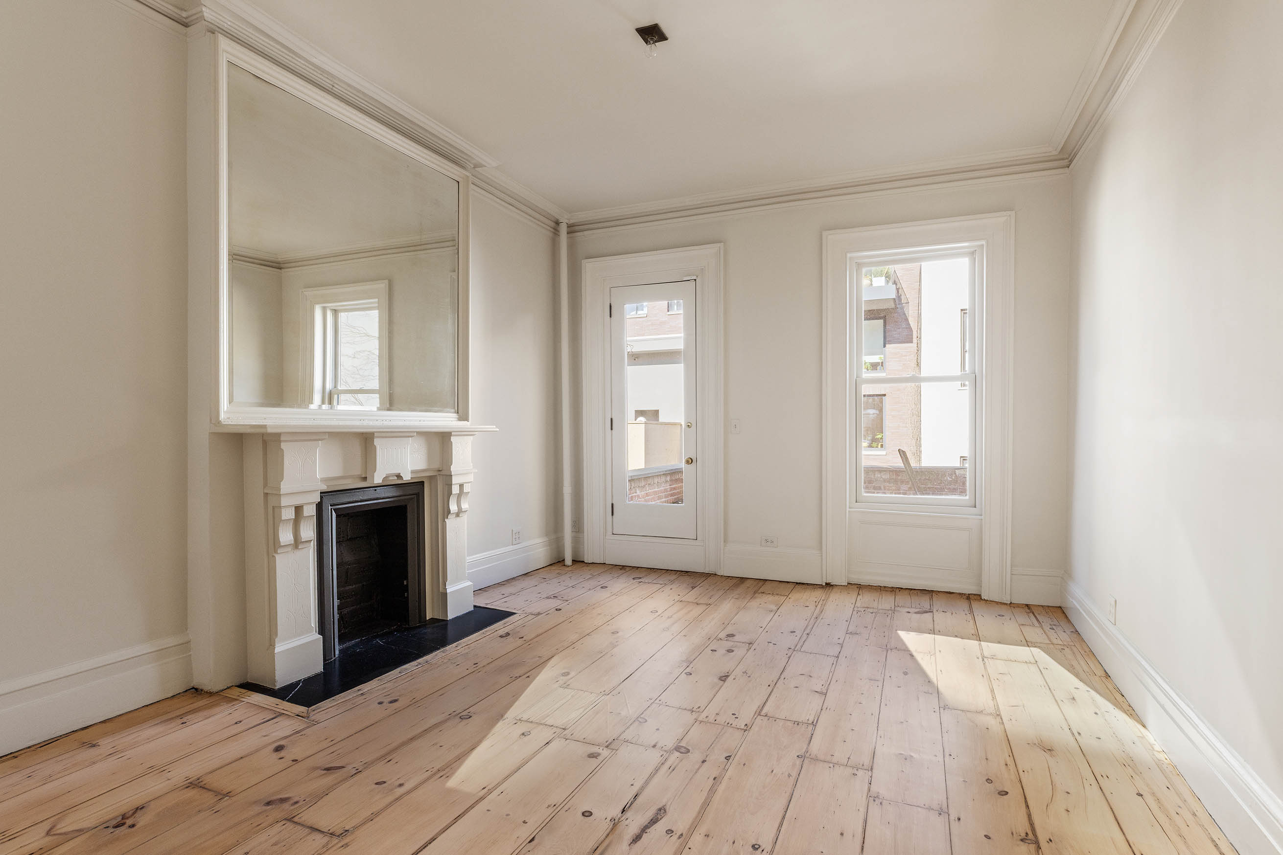 125 West 15th Street Manhattan, NY 10011 - Photo 21 of 28 a view of empty room with a fireplace and wooden floor