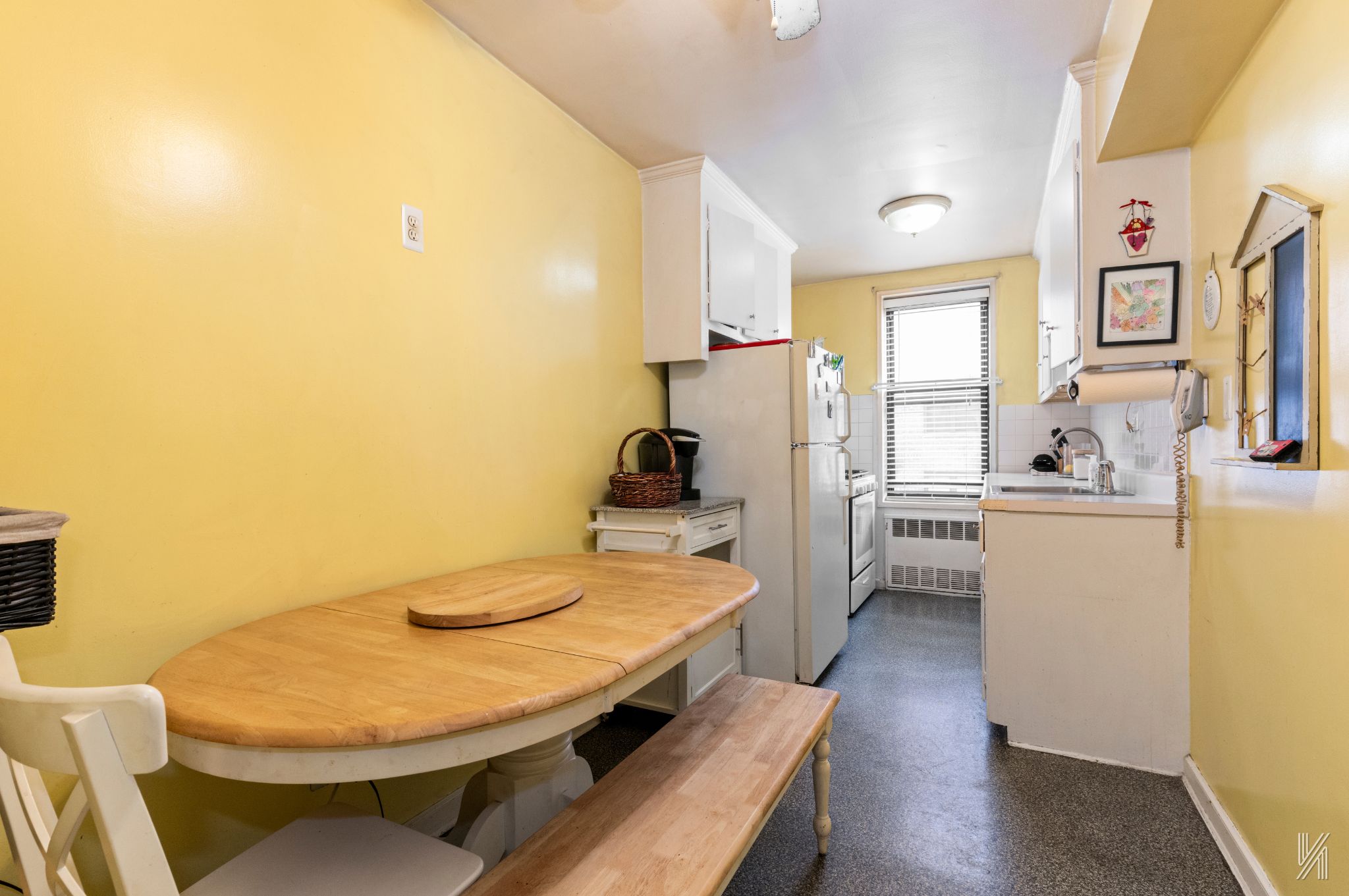 33-27 91st Street, Unit 3J Queens, NY 11372 - Photo 4 of 13 a kitchen with a table chairs refrigerator and a stove