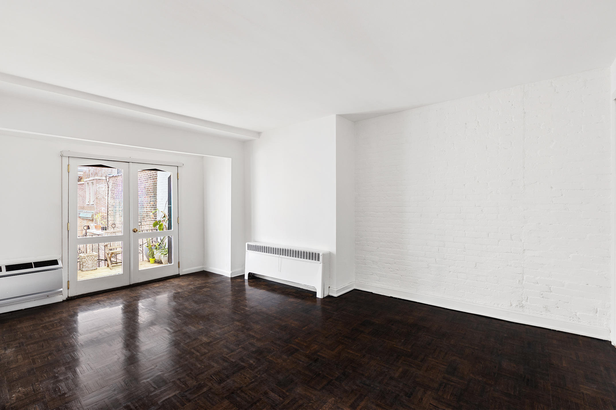 7 East 74th Street, Unit PH Manhattan, NY 10021 - Photo 8 of 10 a view of an empty room with wooden floor and a window