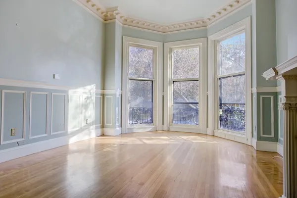 a view of a big room with wooden floor and windows