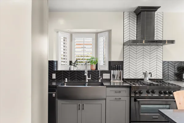 a kitchen with stainless steel appliances granite countertop a sink a stove and a wooden cabinets