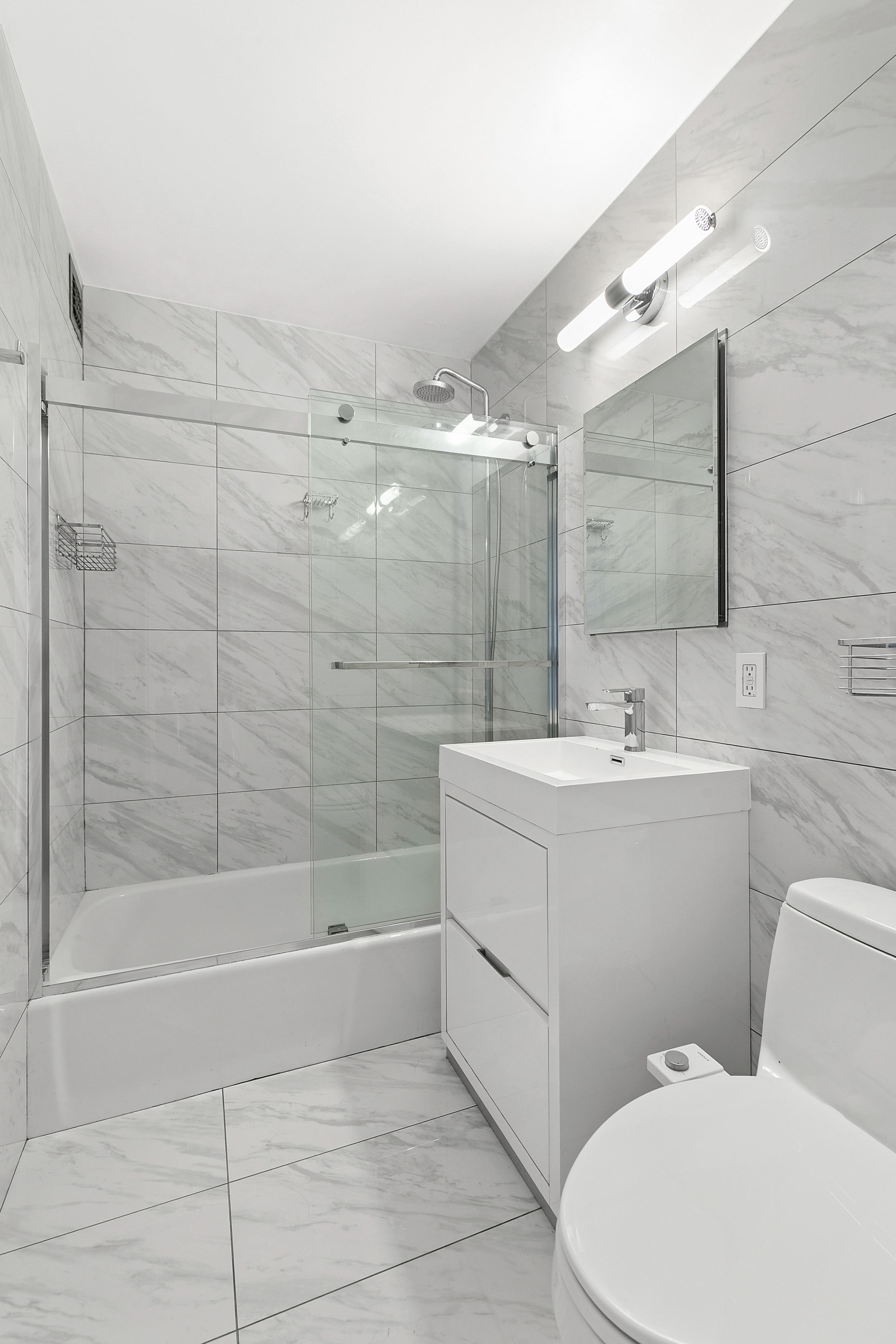 201 East 17th Street, Unit 30F New York, NY 10003 - Photo 6 of 14 a bathroom with a sink a toilet and shower