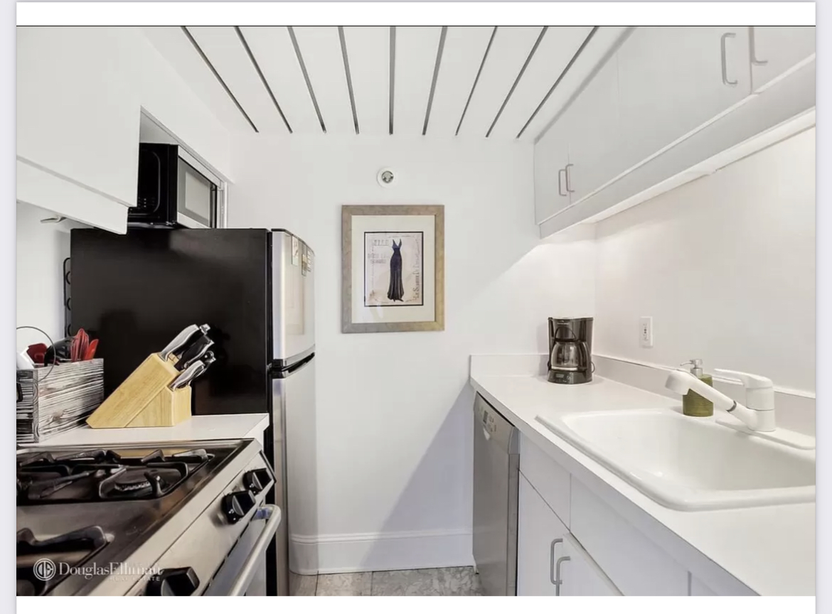421 Hudson Street, Unit 502 Manhattan, NY 10014 - Photo 5 of 11 a kitchen with stainless steel appliances a sink a stove and a refrigerator
