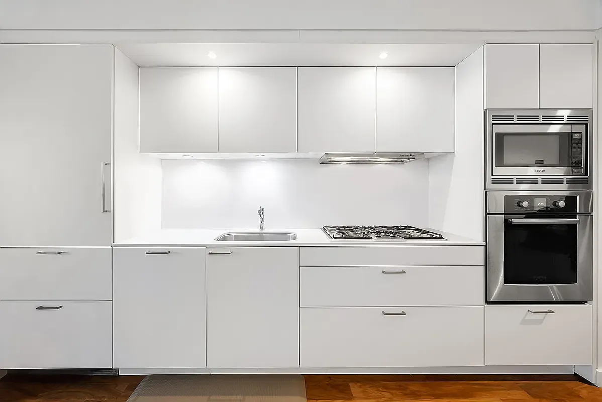 84 White Street, Unit 4A Manhattan, NY 10013 - Photo 5 of 7 a kitchen with granite countertop white cabinets and stainless steel appliances