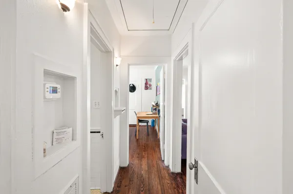 a view of a hallway with wooden floor and closet