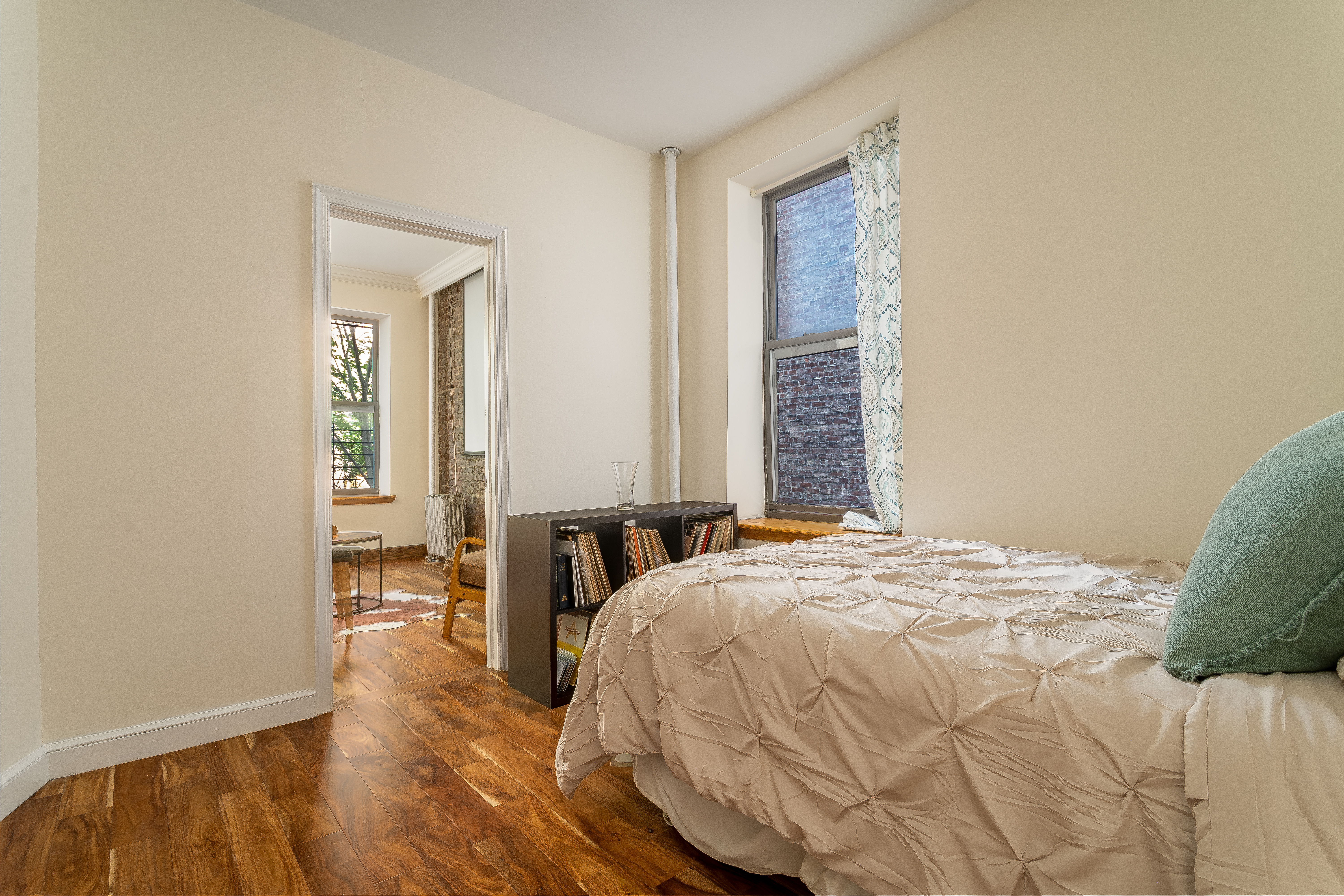 100 West 141st Street, Unit 33 Manhattan, NY 10030 - Photo 5 of 12 a bed sitting in a bedroom next to a window