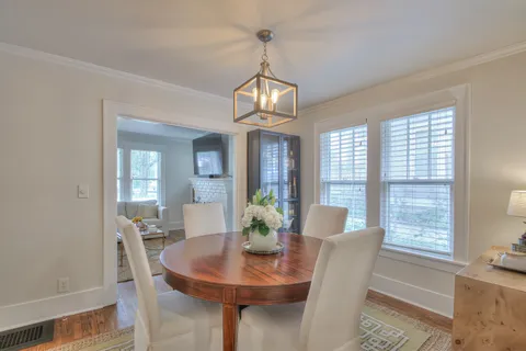 a view of a dining room with furniture wooden floor and a chandelier