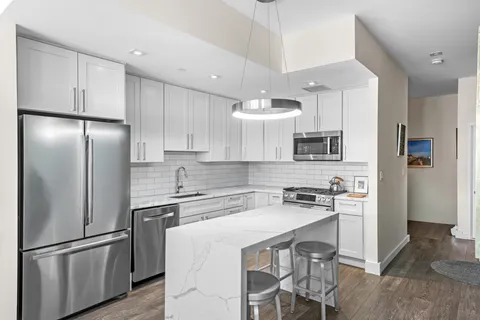 a kitchen with stainless steel appliances a refrigerator stove microwave and cabinets