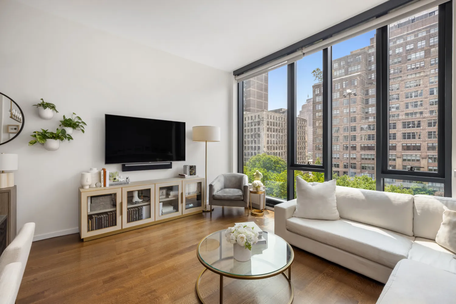 a living room with furniture a flat screen tv and a large window