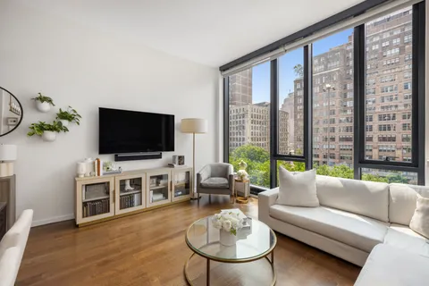 a living room with furniture a flat screen tv and a large window