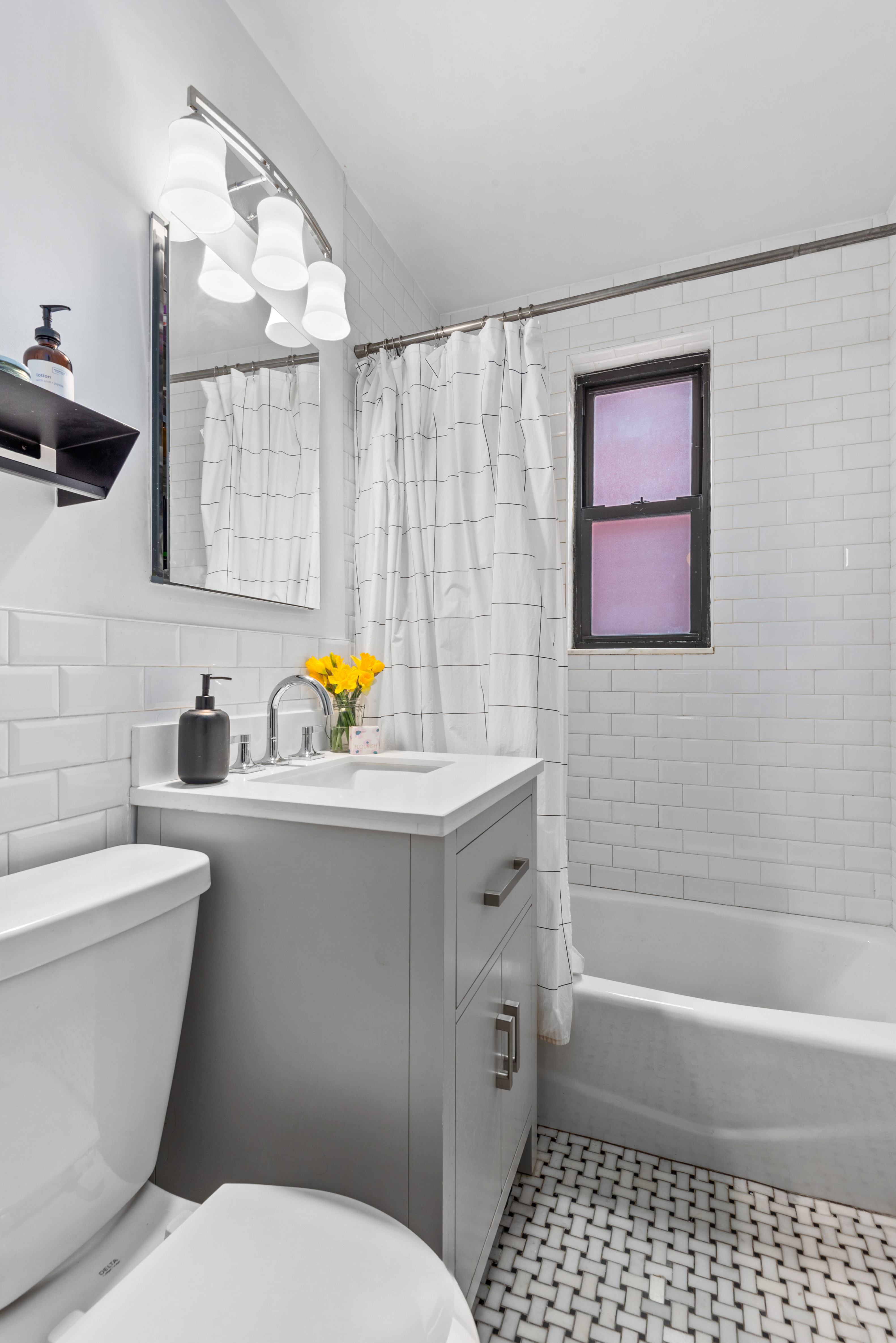 50-54 East 8th Street, Unit 5S Manhattan, NY 10003 - Photo 6 of 8 a bathroom with a sink a toilet and shower