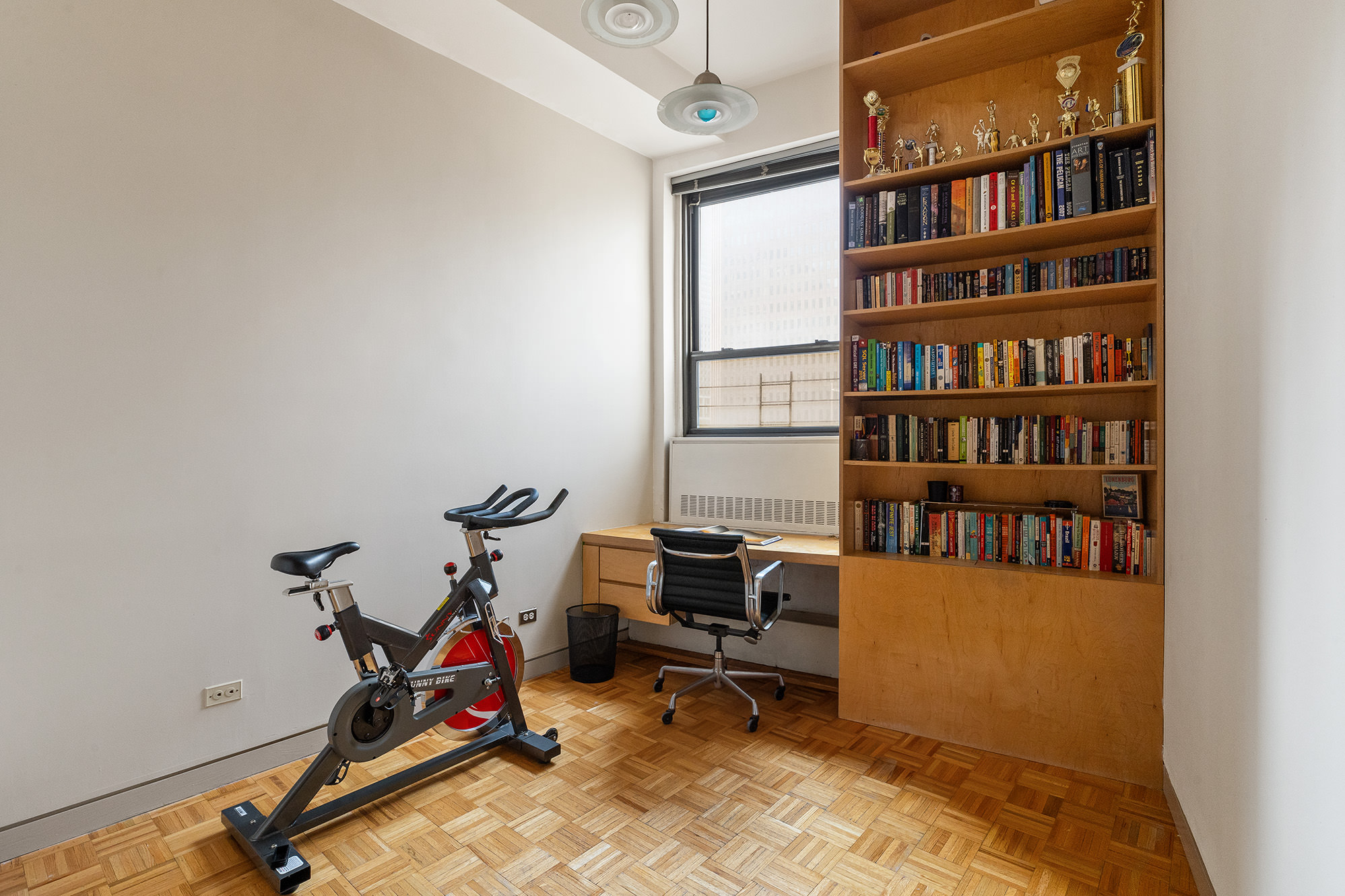 3 Hanover Square, Unit 14EF Manhattan, NY 10004 - Photo 11 of 14 a view of a workspace with furniture and a bookshelf