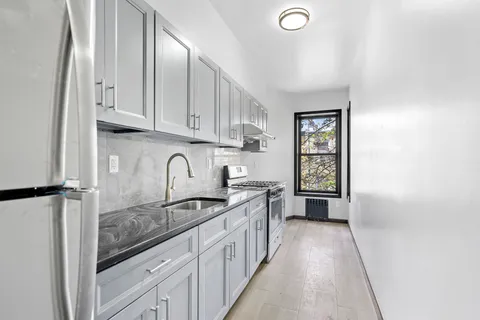 a kitchen with granite countertop a sink stove and cabinets