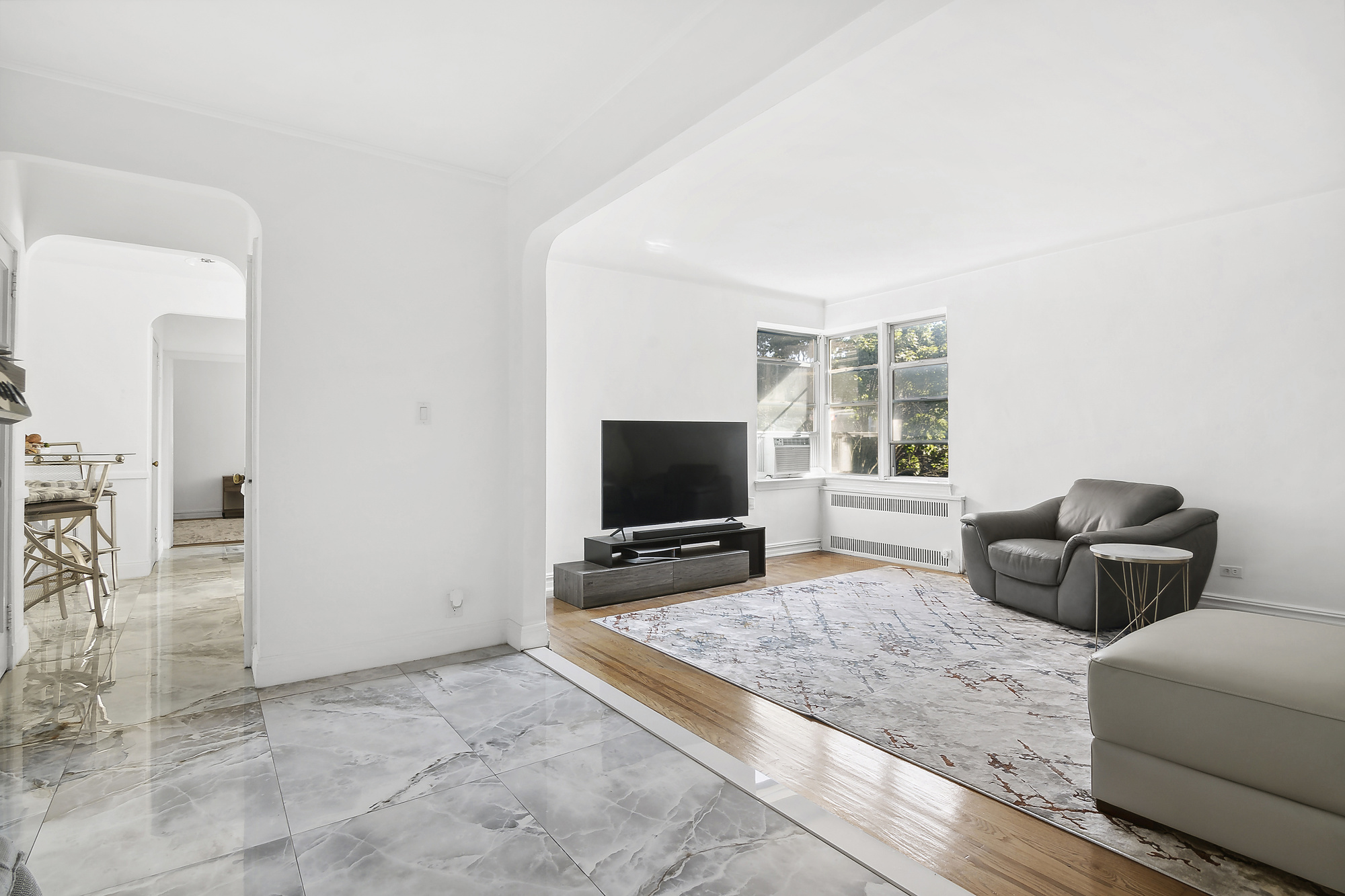 1615 Avenue I, Unit 611 Brooklyn, NY 11230 - Photo 2 of 5 a living room with furniture and a flat screen tv