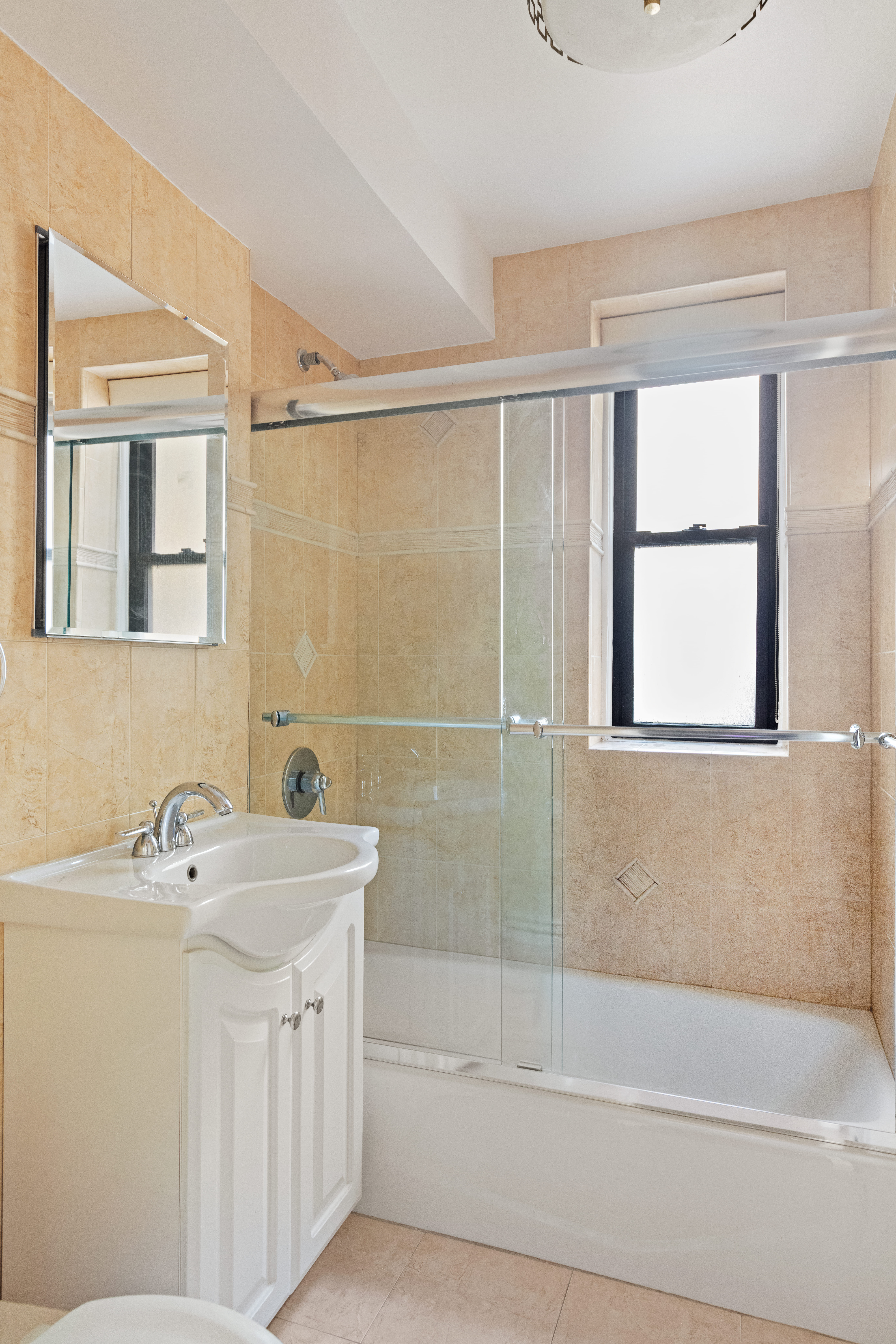 30 East 9th Street, Unit 2II Manhattan, NY 10003 - Photo 9 of 10 a bathroom with a sink a mirror and a bathtub