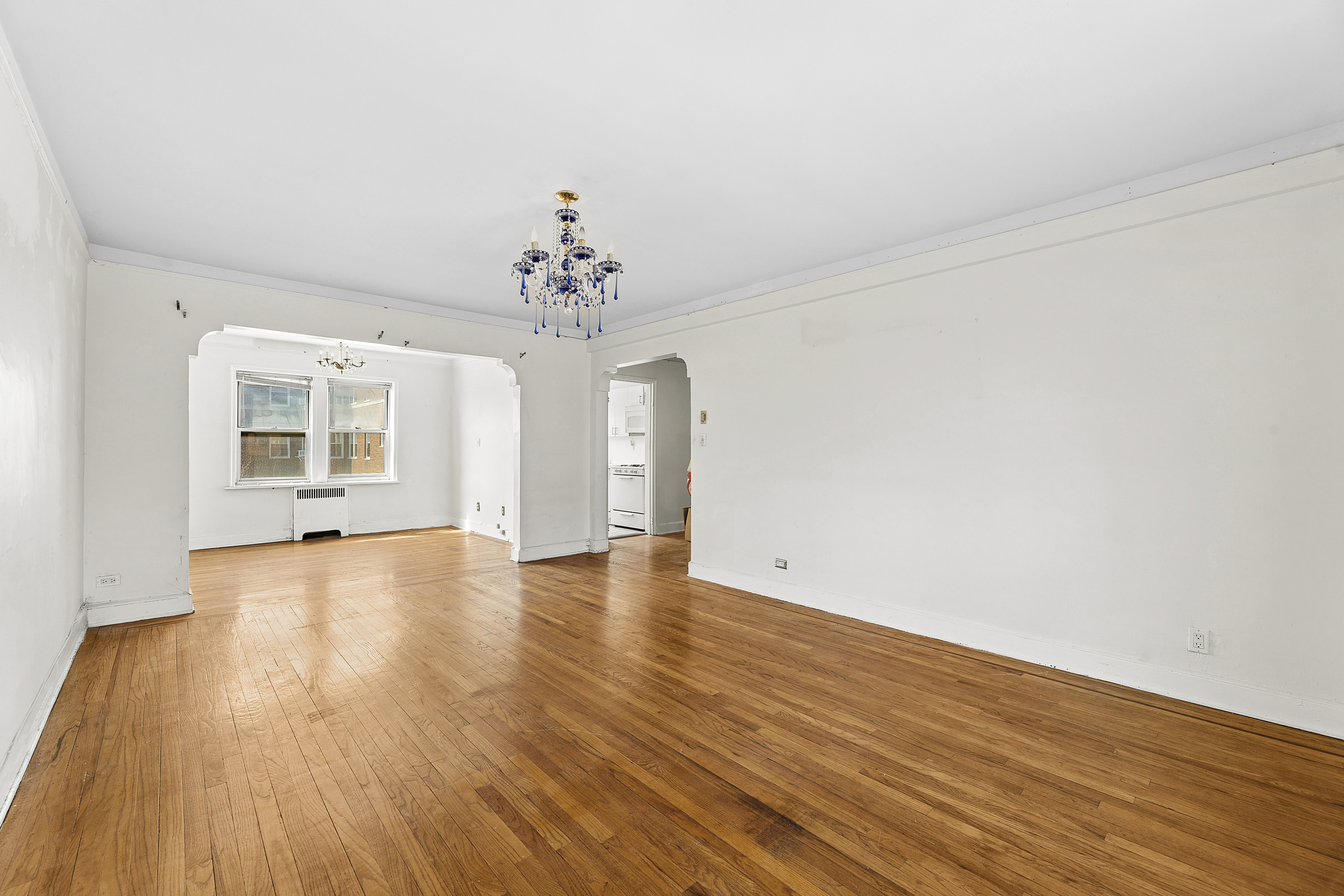 5444 Arlington Avenue, Unit G51 Bronx, NY 10471 - Photo 2 of 16 a view of an empty room with wooden floor and a window