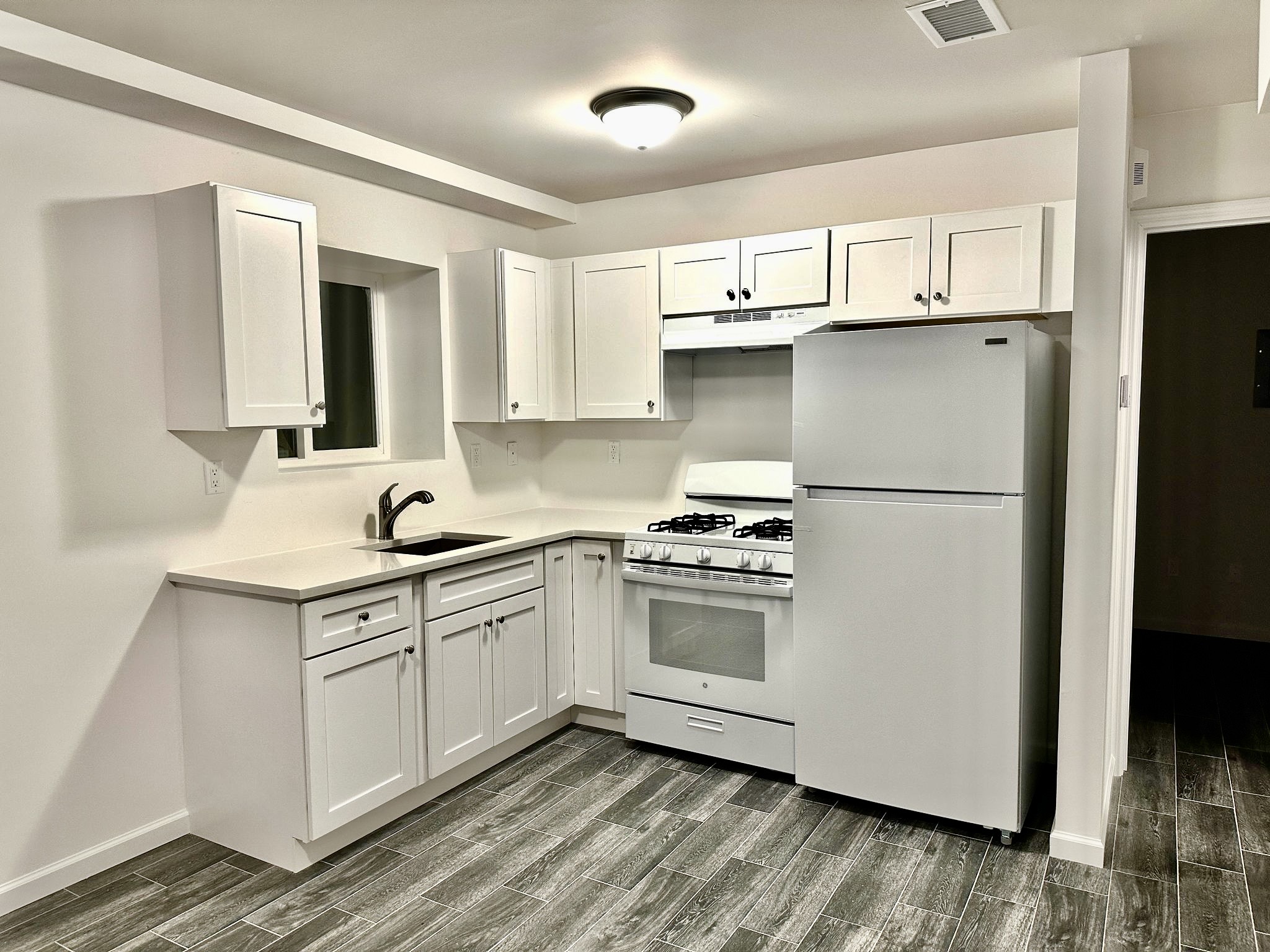 152 Davis Avenue, Unit 1 Staten Island, NY 10310 - Photo 2 of 7 a kitchen with a sink a refrigerator and cabinets