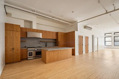 a kitchen with stainless steel appliances granite countertop a refrigerator a stove and a wooden floors