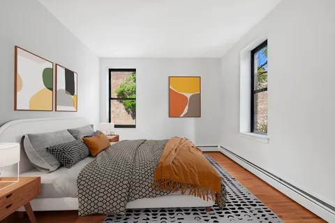 a bedroom with a bed and wooden floor