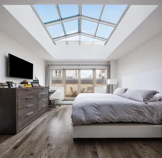 a bedroom with a bed and a flat tv screen on the dresser