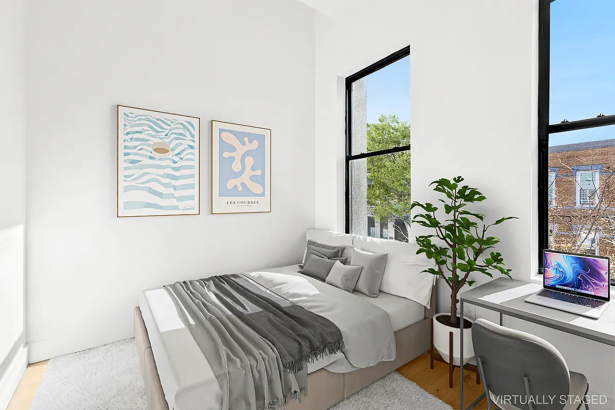 a bedroom with a large bed and a potted plant