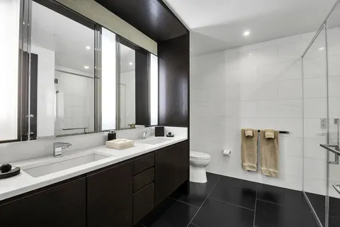 a bathroom with a double vanity sink a mirror and a toilet
