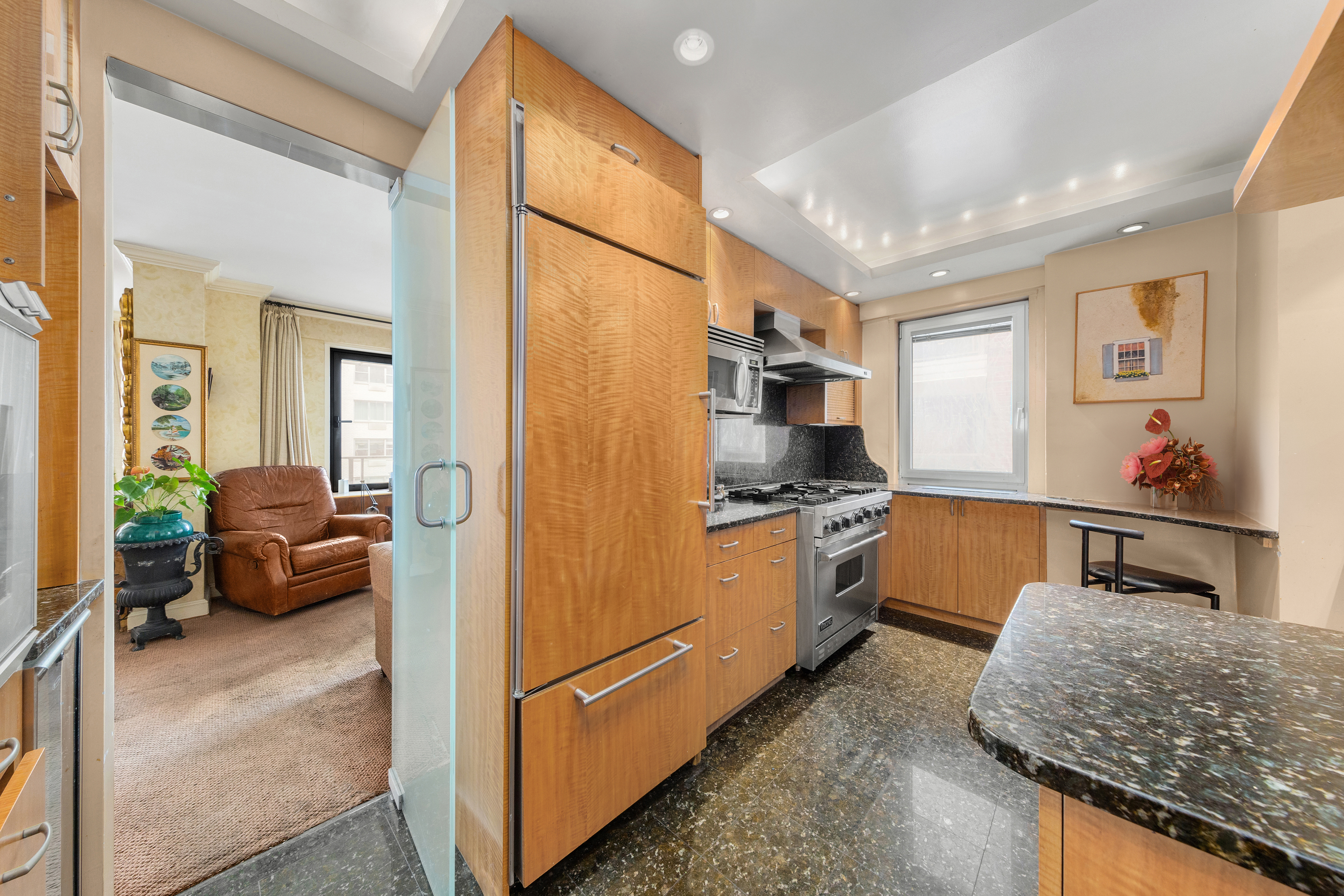 50 Sutton Place South, Unit 9F Manhattan, NY 10022 - Photo 5 of 10 a kitchen with stainless steel appliances granite countertop a refrigerator and a sink