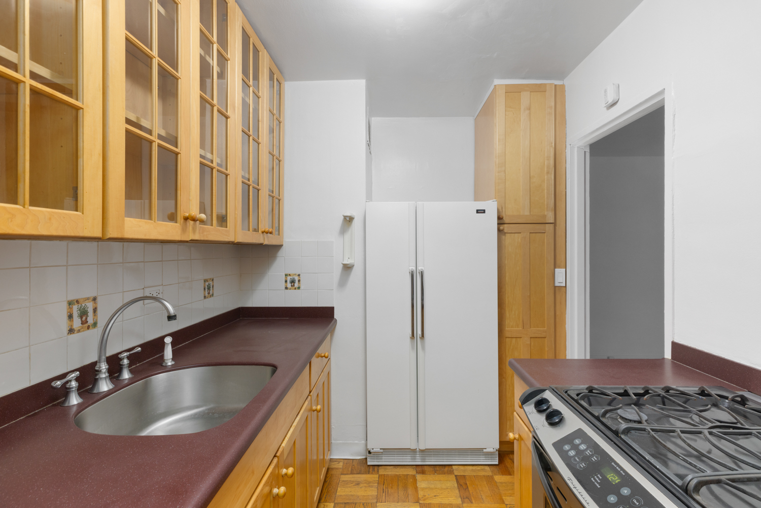 136 East 56th Street, Unit 9J Manhattan, NY 10022 - Photo 11 of 14 a kitchen with stainless steel appliances granite countertop a sink stove and refrigerator