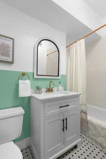 a bathroom with a toilet sink and mirror