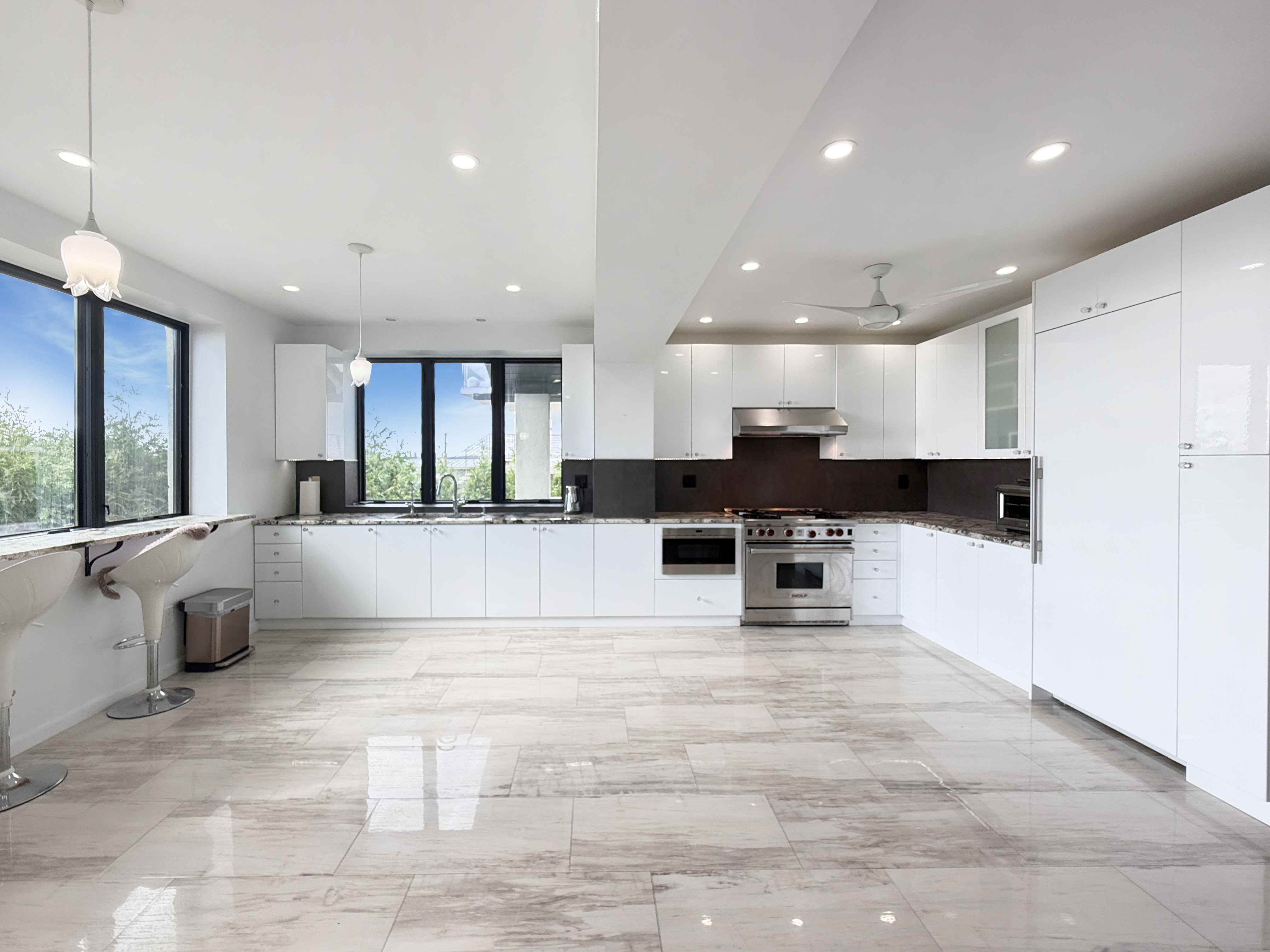 3848 Atlantic Avenue Brooklyn, NY 11224 - Photo 7 of 29 a view of kitchen with stainless steel appliances kitchen island granite countertop a stove a sink a refrigerator and white cabinets with wooden floor
