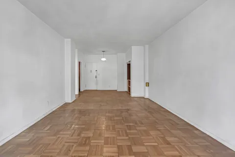 a view of an empty room with cabinet and a window