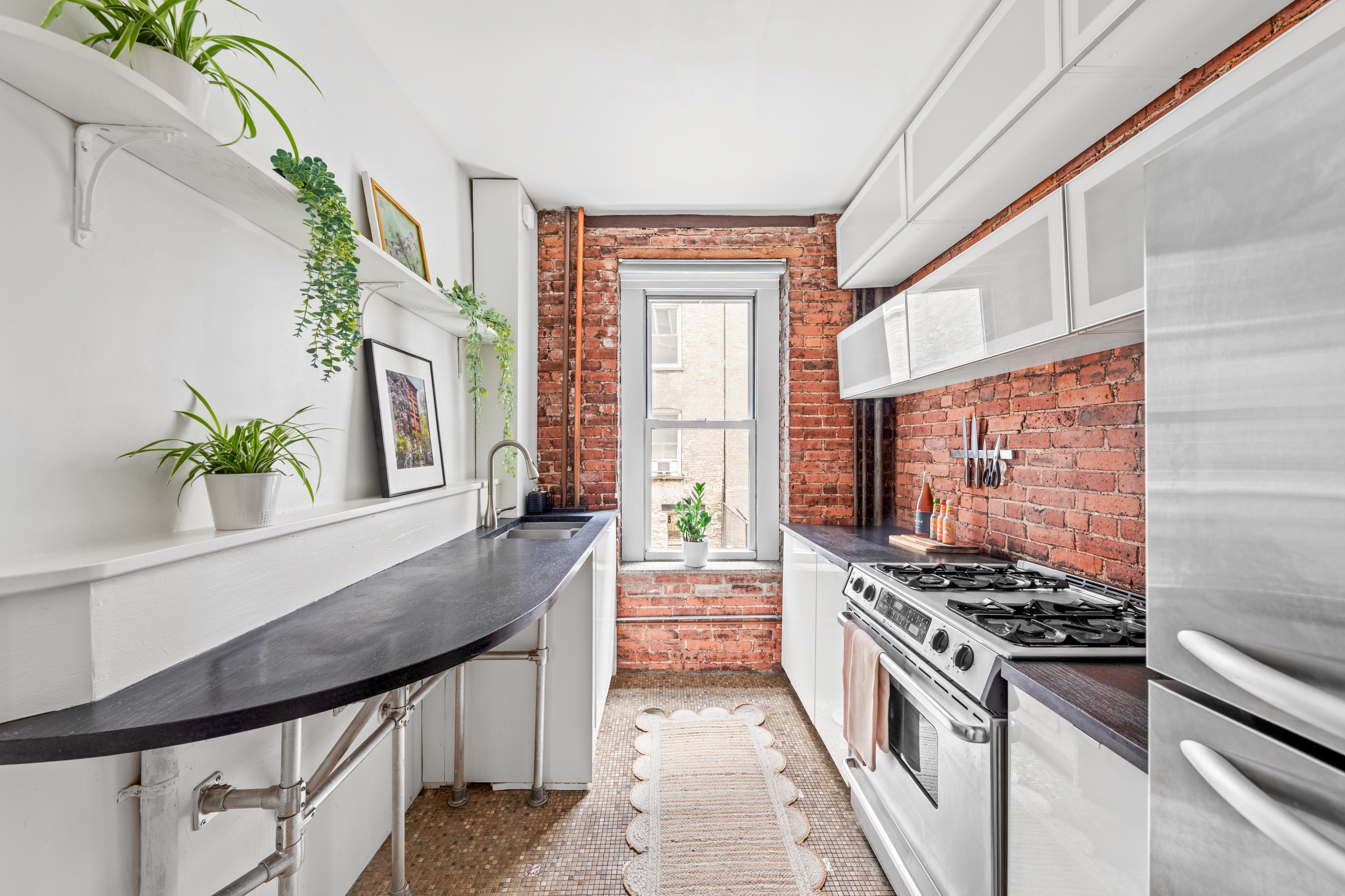 317 West 93rd Street, Unit 1C Manhattan, NY 10025 - Photo 4 of 9 a kitchen with stainless steel appliances a stove a sink and a refrigerator